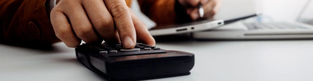 A business owner using a calculator at a desk.